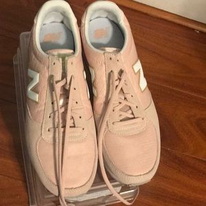 Pink New Balances with gold and white accents.